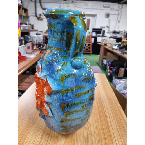 320 - A very large unusual West German glazed jug vase in blue and green with an orange flower design to t... 