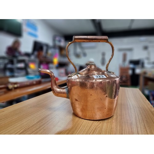 323 - A good quality antique copper kettle with a copper handle and a porcelain nob, in clean polished con... 