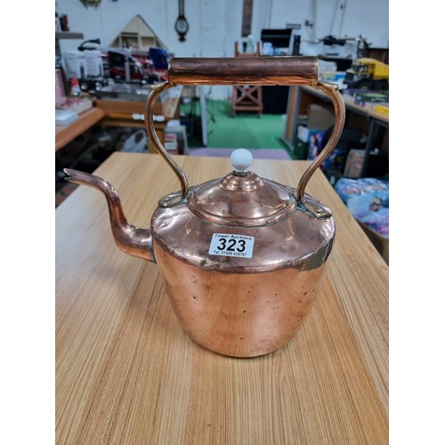 323 - A good quality antique copper kettle with a copper handle and a porcelain nob, in clean polished con... 