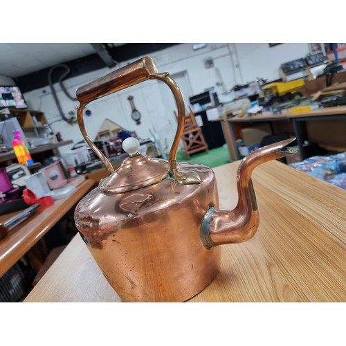 323 - A good quality antique copper kettle with a copper handle and a porcelain nob, in clean polished con... 