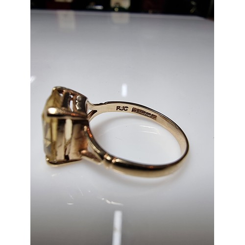 395 - A pretty 9ct yellow gold vintage dress ring inset with a large faceted citrine gemstone. Size of sto... 