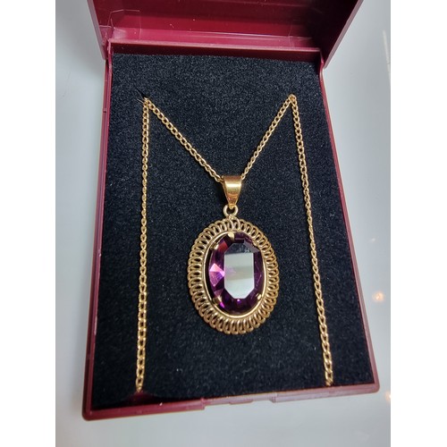 397 - A very pretty rolled gold pendant with a large faceted purple crystal glass stone set on a 16