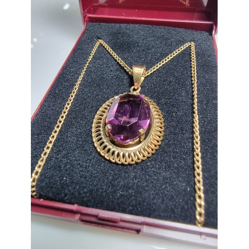 397 - A very pretty rolled gold pendant with a large faceted purple crystal glass stone set on a 16