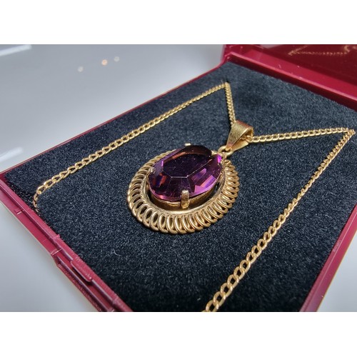 397 - A very pretty rolled gold pendant with a large faceted purple crystal glass stone set on a 16