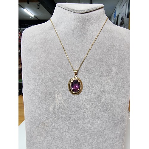 397 - A very pretty rolled gold pendant with a large faceted purple crystal glass stone set on a 16