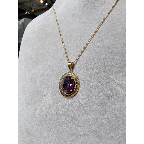 397 - A very pretty rolled gold pendant with a large faceted purple crystal glass stone set on a 16