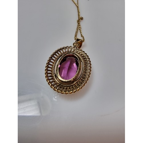 397 - A very pretty rolled gold pendant with a large faceted purple crystal glass stone set on a 16