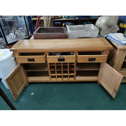 496 - A solid oak sideboard, 3 drawers over 2 doors with a 16 division wine rack in the middle, in good or... 