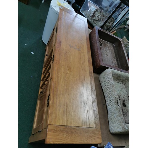 496 - A solid oak sideboard, 3 drawers over 2 doors with a 16 division wine rack in the middle, in good or... 