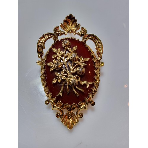 386 - A pretty ornate hallmarked 9ct yellow gold pendant/brooch inset with a large oval carnelian stone ov... 