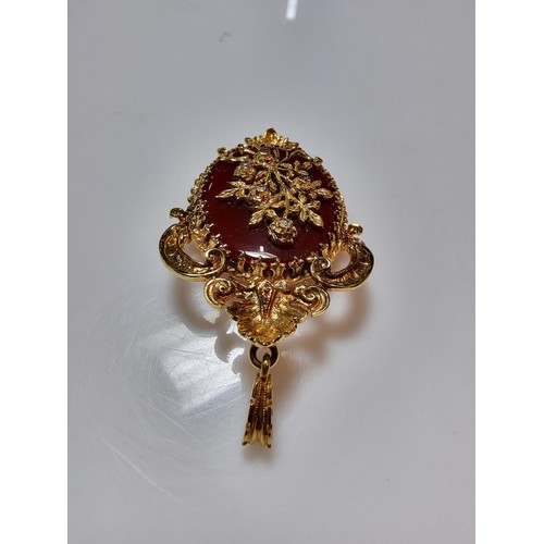 386 - A pretty ornate hallmarked 9ct yellow gold pendant/brooch inset with a large oval carnelian stone ov... 