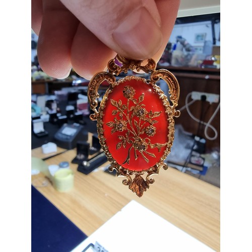 386 - A pretty ornate hallmarked 9ct yellow gold pendant/brooch inset with a large oval carnelian stone ov... 