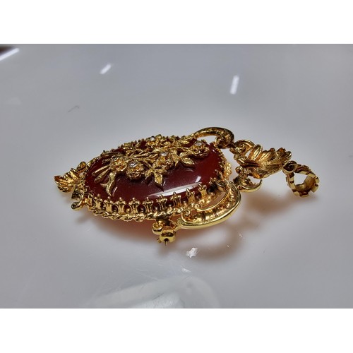 386 - A pretty ornate hallmarked 9ct yellow gold pendant/brooch inset with a large oval carnelian stone ov... 