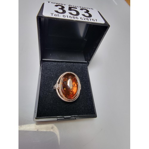 353 - A good quality 925 silver dress ring inset with a large oval Baltic amber stone presenting good oran... 