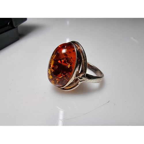 353 - A good quality 925 silver dress ring inset with a large oval Baltic amber stone presenting good oran... 