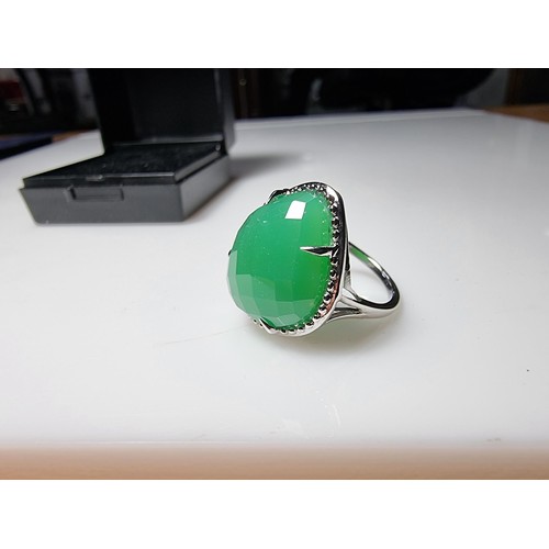 354 - A good quality 925 silver dress ring inset with a large faceted green chalcedony crystal, unused in ... 