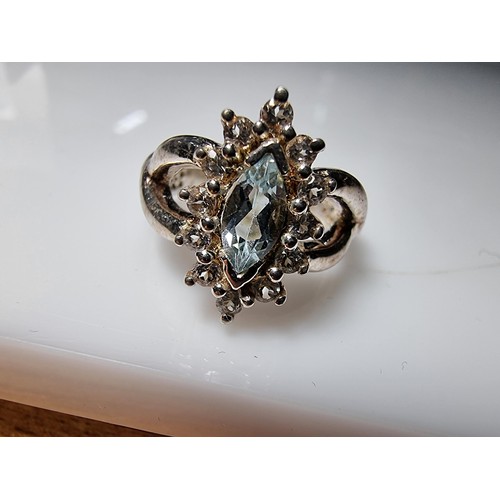 360 - A good quality ornate 925 silver dress ring inset with a blue topaz stone 1.25ct surrounded by small... 