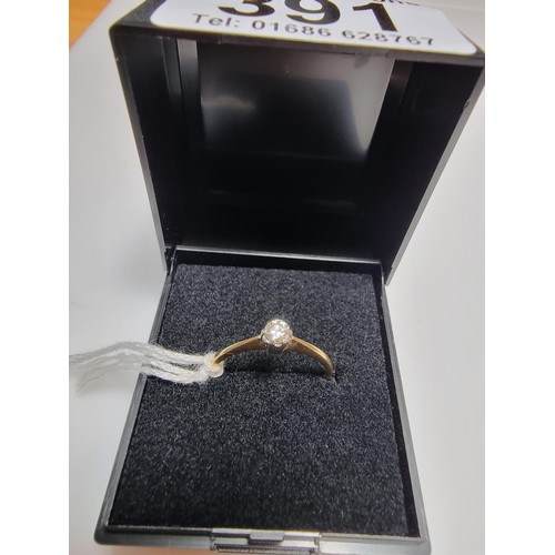 391 - A hallmarked 18ct yellow gold diamond solitaire ring inset with a 0.15ct diamond which is lively and... 