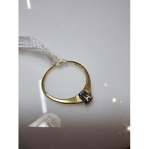 391 - A hallmarked 18ct yellow gold diamond solitaire ring inset with a 0.15ct diamond which is lively and... 