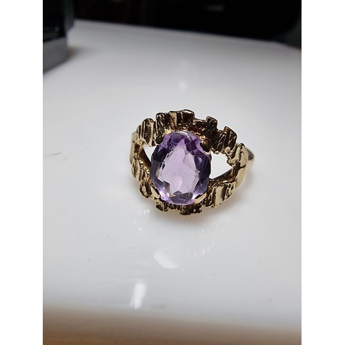 392 - A vintage 9ct hallmarked yellow gold ring with a bark effect, inset with a large faceted amethyst ge... 