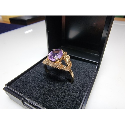 392 - A vintage 9ct hallmarked yellow gold ring with a bark effect, inset with a large faceted amethyst ge... 