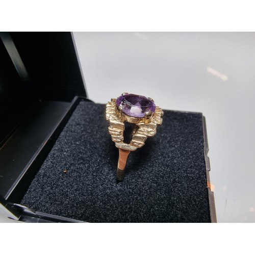 392 - A vintage 9ct hallmarked yellow gold ring with a bark effect, inset with a large faceted amethyst ge... 