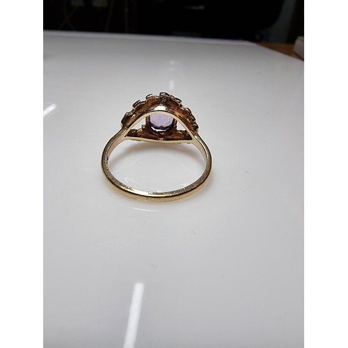 392 - A vintage 9ct hallmarked yellow gold ring with a bark effect, inset with a large faceted amethyst ge... 