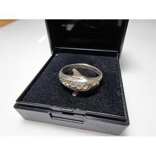 362 - A clean 925 silver dolphin ring inset with clear CZ stones, size O, boxed.