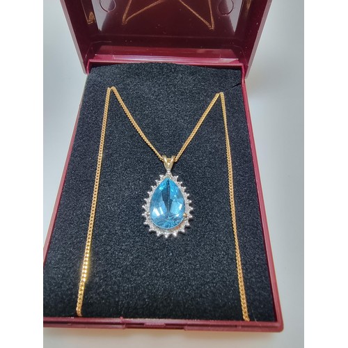 393 - A pretty hallmarked 9ct yellow gold pendant inset with a large genuine faceted blue topaz stone surr... 