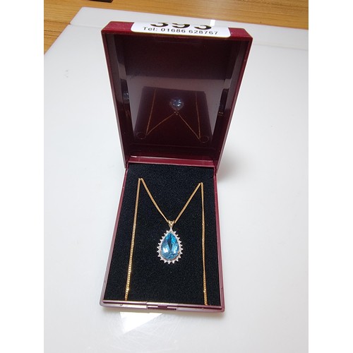 393 - A pretty hallmarked 9ct yellow gold pendant inset with a large genuine faceted blue topaz stone surr... 