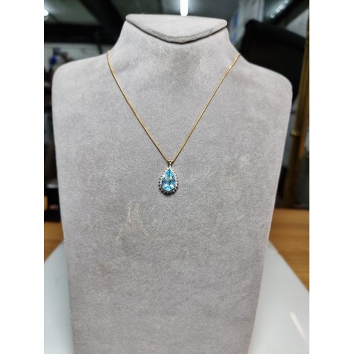 393 - A pretty hallmarked 9ct yellow gold pendant inset with a large genuine faceted blue topaz stone surr... 