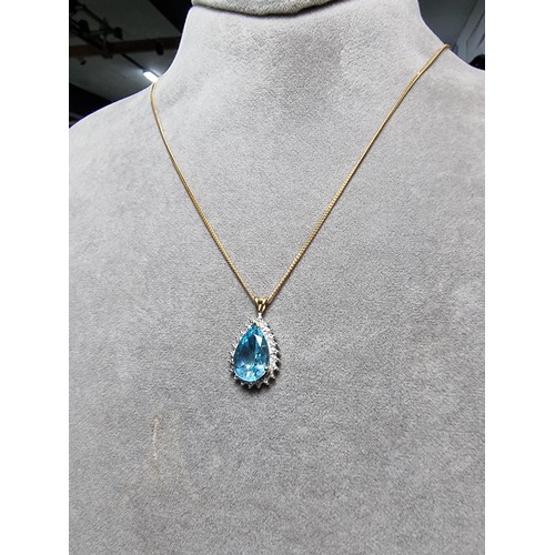 393 - A pretty hallmarked 9ct yellow gold pendant inset with a large genuine faceted blue topaz stone surr... 