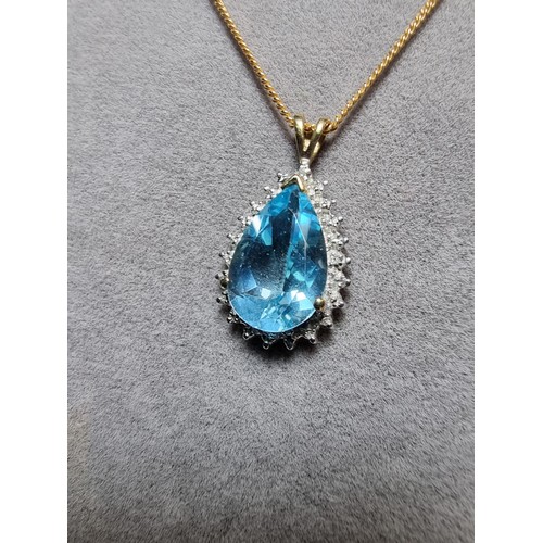 393 - A pretty hallmarked 9ct yellow gold pendant inset with a large genuine faceted blue topaz stone surr... 