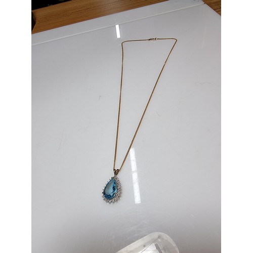 393 - A pretty hallmarked 9ct yellow gold pendant inset with a large genuine faceted blue topaz stone surr... 