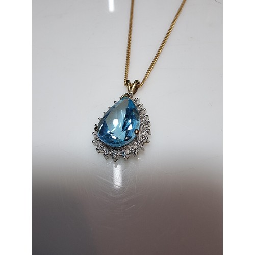 393 - A pretty hallmarked 9ct yellow gold pendant inset with a large genuine faceted blue topaz stone surr... 