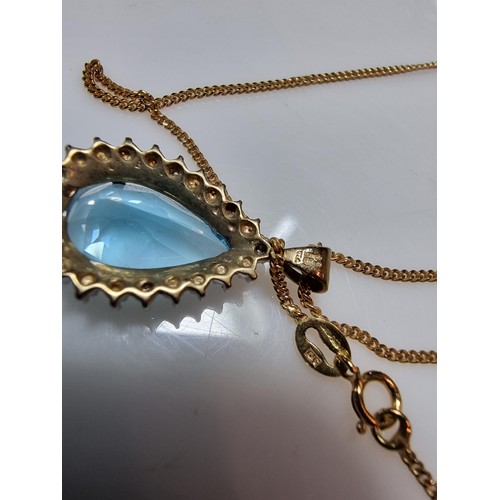 393 - A pretty hallmarked 9ct yellow gold pendant inset with a large genuine faceted blue topaz stone surr... 