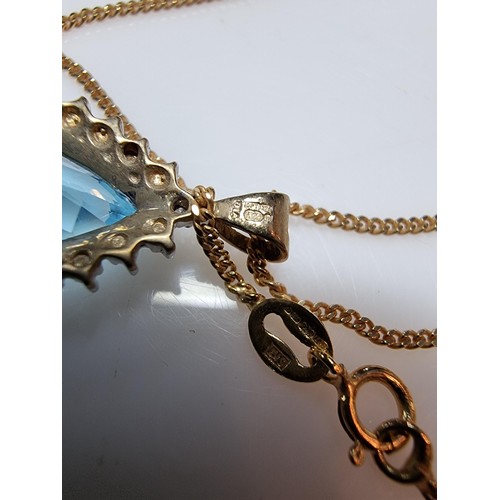 393 - A pretty hallmarked 9ct yellow gold pendant inset with a large genuine faceted blue topaz stone surr... 