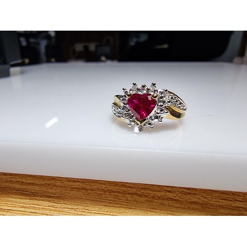 398 - A pretty hallmarked 9ct yellow gold ring inset with a heart shaped hot pink topaz stone surrounded b... 