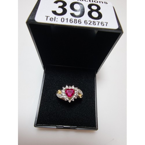 398 - A pretty hallmarked 9ct yellow gold ring inset with a heart shaped hot pink topaz stone surrounded b... 