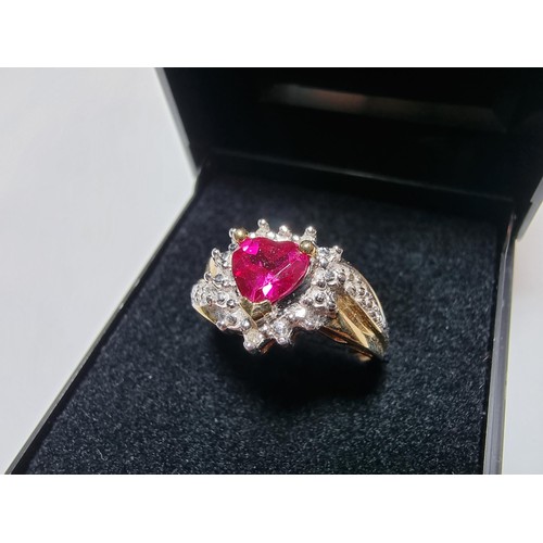 398 - A pretty hallmarked 9ct yellow gold ring inset with a heart shaped hot pink topaz stone surrounded b... 