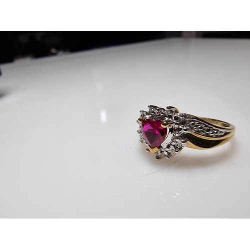 398 - A pretty hallmarked 9ct yellow gold ring inset with a heart shaped hot pink topaz stone surrounded b... 