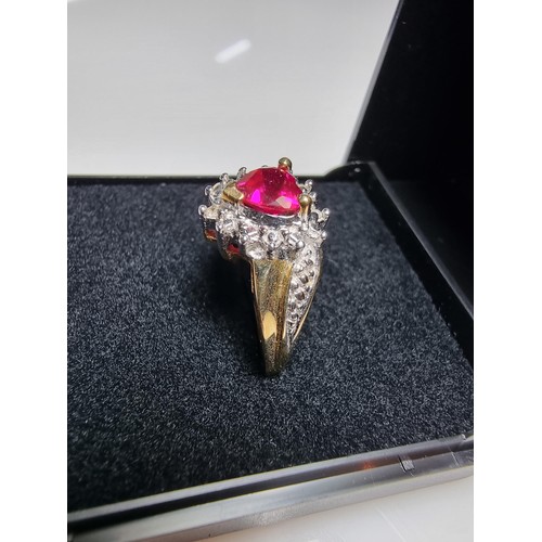 398 - A pretty hallmarked 9ct yellow gold ring inset with a heart shaped hot pink topaz stone surrounded b... 