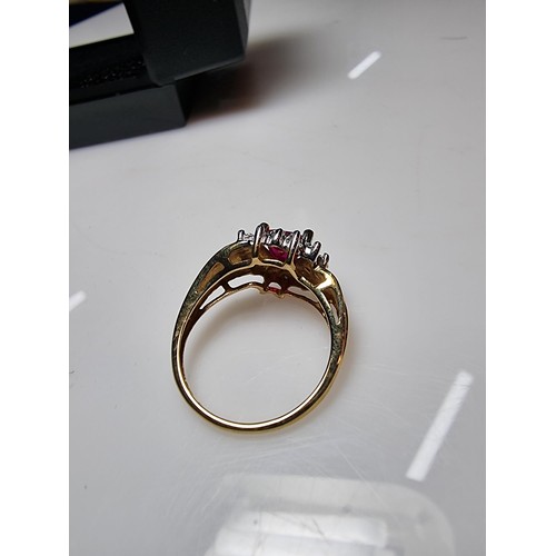 398 - A pretty hallmarked 9ct yellow gold ring inset with a heart shaped hot pink topaz stone surrounded b... 