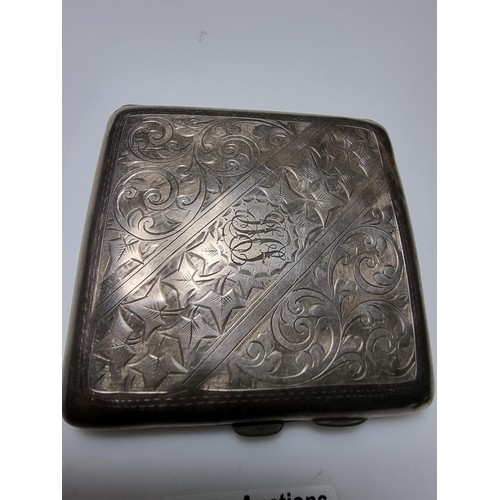 370 - A hallmarked silver cigarette case with an ornate engraved design and shaped for the hip. In good cl... 