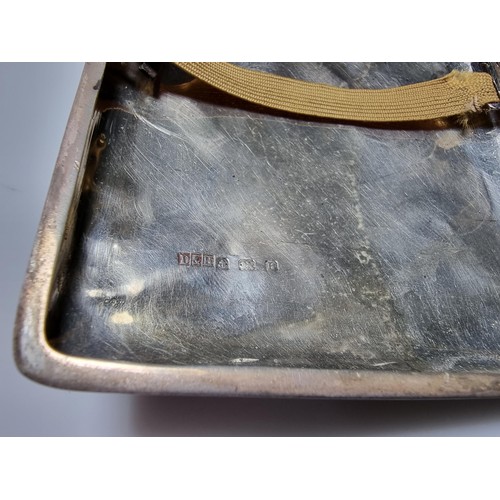 370 - A hallmarked silver cigarette case with an ornate engraved design and shaped for the hip. In good cl... 