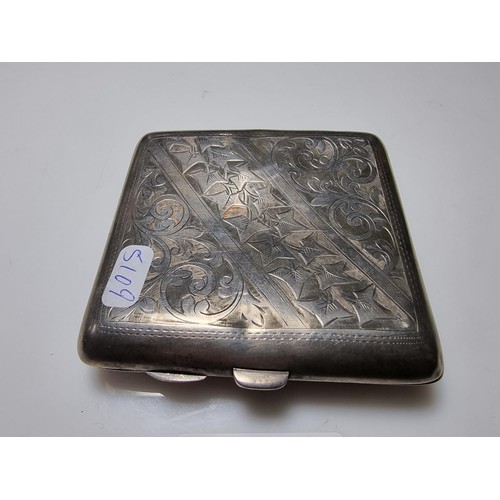 370 - A hallmarked silver cigarette case with an ornate engraved design and shaped for the hip. In good cl... 