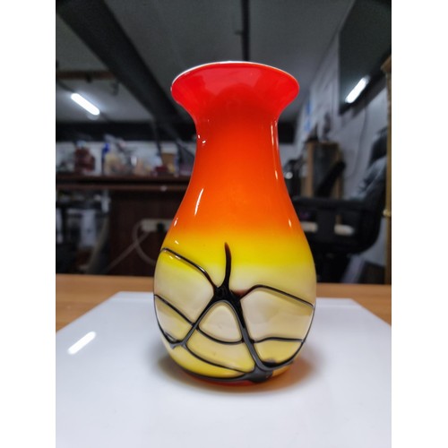 405 - A stunning art glass vase in sunset colours with an overlaid black web design to the base by an unkn... 