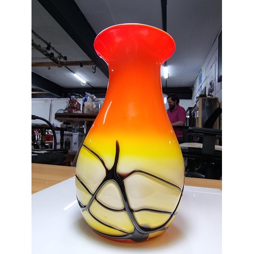 405 - A stunning art glass vase in sunset colours with an overlaid black web design to the base by an unkn... 