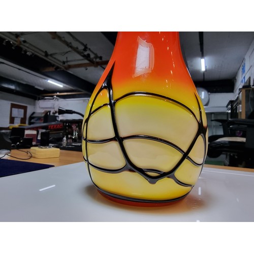 405 - A stunning art glass vase in sunset colours with an overlaid black web design to the base by an unkn... 