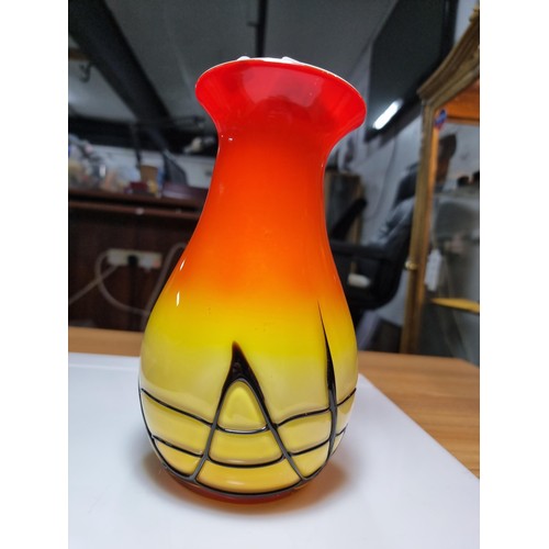 405 - A stunning art glass vase in sunset colours with an overlaid black web design to the base by an unkn... 